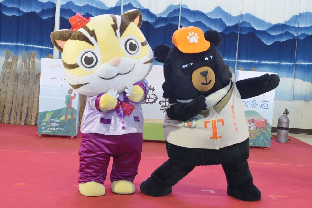 交通部觀光局吉祥物「哦熊」，14日南下與苗栗在地吉祥物「貓裏喵」合體